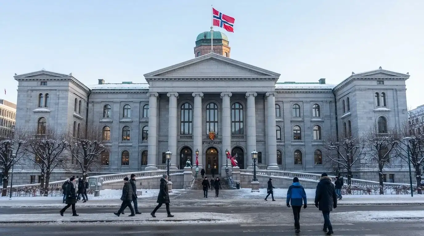 Statlig bygning i grå stein med flaggstang i klar vinterluft, folk går forbi på fortauet